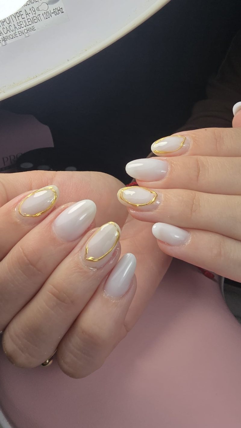 Uñas blanco lechoso con detalles de oro líquido