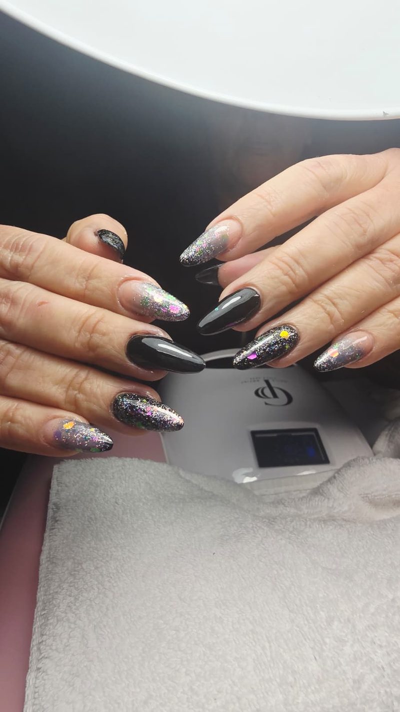 Uñas almendra en negro con glitter holográfico y confeti de colores