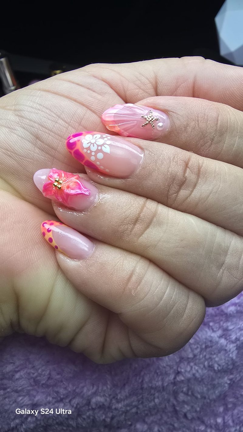 Uñas almendra en rosa y naranja con flor 3D fucsia, estrella dorada y flores blancas pintadas